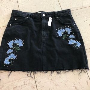 Black denim skirt w/ blue floral embellishments